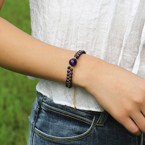 Amethyst cosmic eclipse bracelet worn on a woman's wrist with a white top and denim