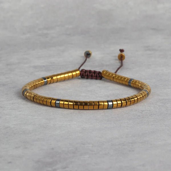 Gold hematite bracelet with grey spacer beads and adjustable cord for wealth and success