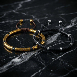 Matching gold hematite and black onyx bracelet pair for couples on polished black marble