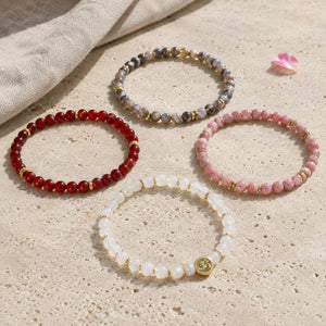 Change 4 mm crystal bracelet stack - four bracelets on a sunlit table