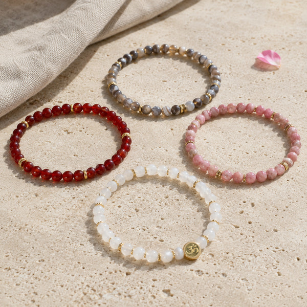 Change 4 mm crystal bracelet stack - four bracelets on a sunlit table