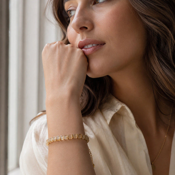 Citrine bracelet with golden hematite worn on a woman's wrist in soft natural light