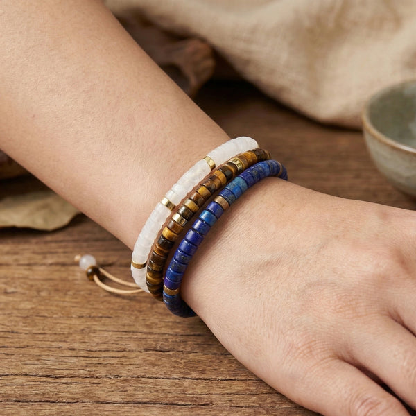 Clear quartz, tiger eye and lapis lazuli bracelet trio worn on the wrist for focus and confidence