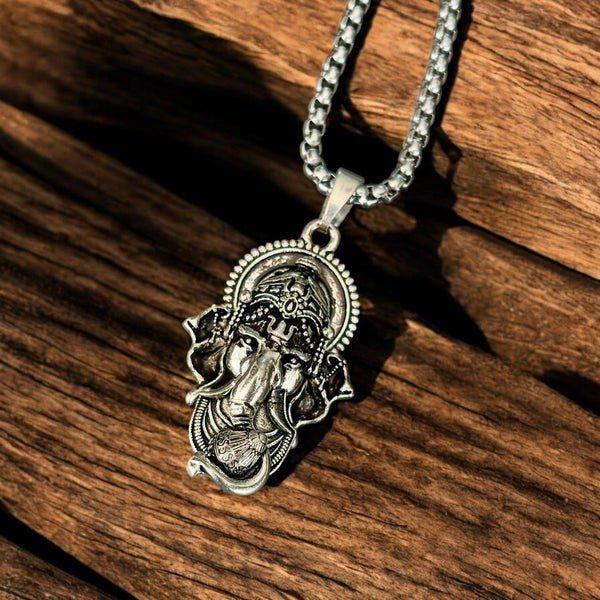 Angle view of silver Lord Ganesha pendant with box chain resting on rustic wood