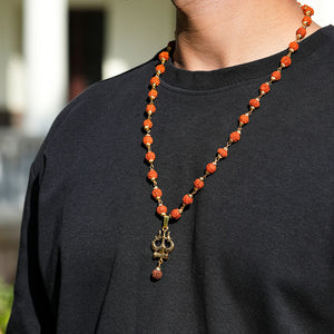 Full length gold plated rudraksha Trishool necklace worn on neck by man outdoors