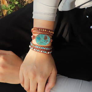 Ocean jasper wrap bracelet styled on wrist outdoors showing turquoise focal stone and layered beads