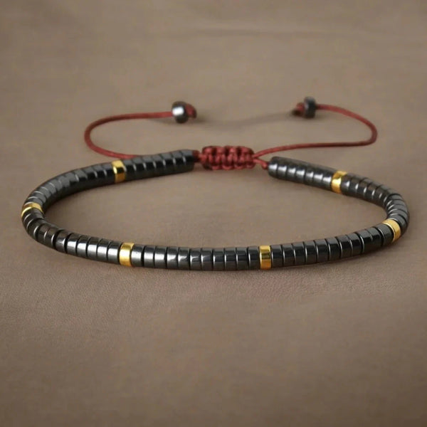 Hematite heishi bead bracelet with gold accents and red adjustable cord for protection