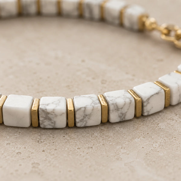 Close-up of white howlite cube beads with grey veining and gold hematite spacers, Soultheory detail