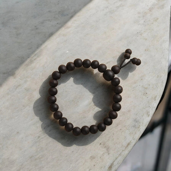 Karungali ebony wood bracelet with matte dark beads on adjustable cord, front view