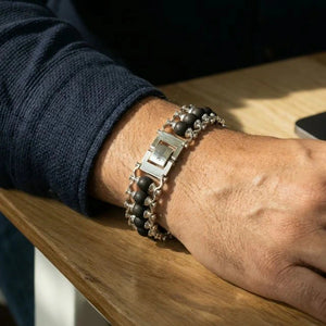 Karungali ebony wood bracelet worn on wrist with silver detailing in natural daylight