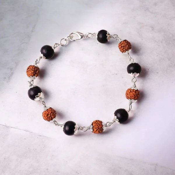 Rudraksha and black karungali bracelet with silver plated caps on white marble