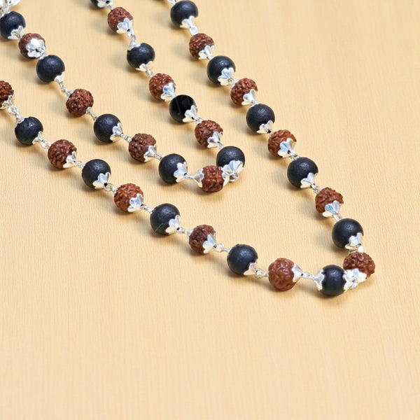Close-up of karungali black beads and rudraksha with silver flower caps and link chain