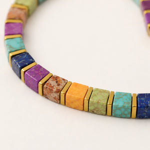 Close-up of multi imperial jasper cube beads in purple, turquoise and orange with gold hematite spacers