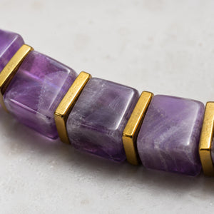 Close-up of translucent purple amethyst cube beads with polished golden hematite spacers
