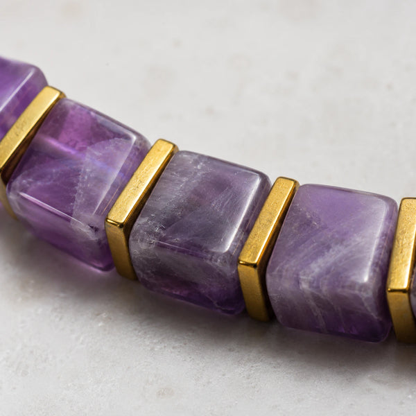 Close-up of translucent purple amethyst cube beads with polished golden hematite spacers