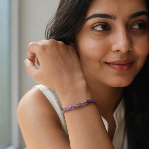 Amethyst bracelet with golden hematite on a woman's wrist for everyday calm, worn with a white top