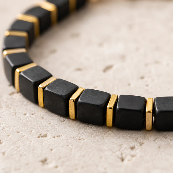 Close-up of black onyx cube beads showing matte black stone and polished golden hematite spacers