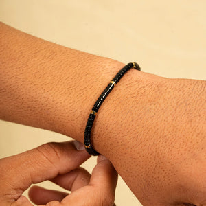 Black onyx heishi bracelet worn on the wrist with gold accent beads for daily focus