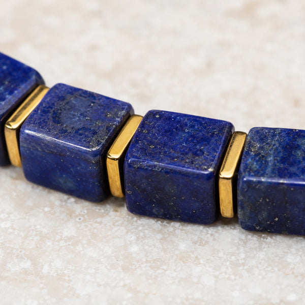 Close-up of deep blue lapis lazuli cube beads with golden pyrite flecks and gold hematite spacers