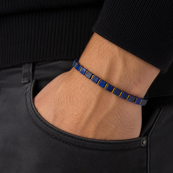 Lapis lazuli bracelet with golden hematite worn on a man's wrist, deep blue cube beads with gold spacers