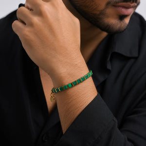 Malachite bracelet with golden hematite worn on a man's wrist with a black shirt for balance