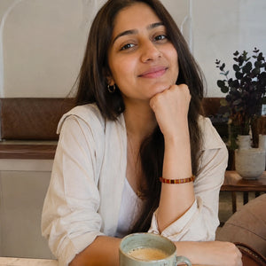 Red striped agate bracelet on a woman's wrist as she enjoys coffee, for everyday confidence