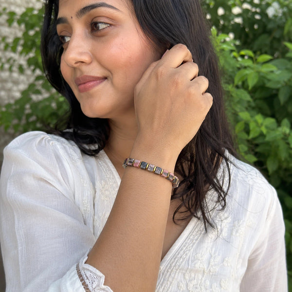 Rhodolite garnet bracelet on a woman's wrist outdoors in a white kurta, styled for passion