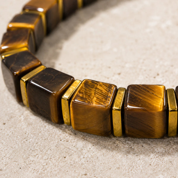Close-up of tiger eye cube beads showing golden brown chatoyant bands and gold hematite spacers