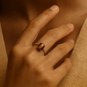 Tiger eye stone ring worn on a model's hand in soft daylight, adjustable band