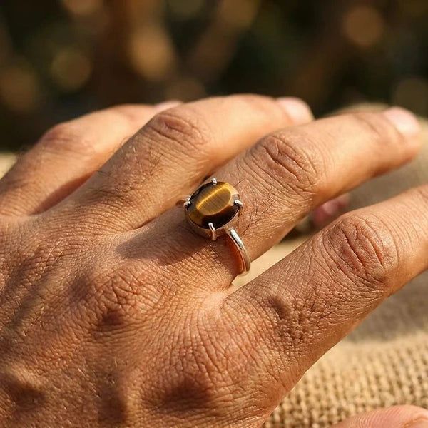 Tiger eye stone ring worn on the finger in natural light, adjustable silver band