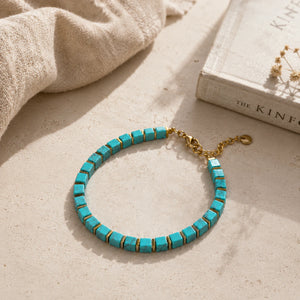 Turquoise and golden hematite bracelet styled on linen beside a book for calm and focus