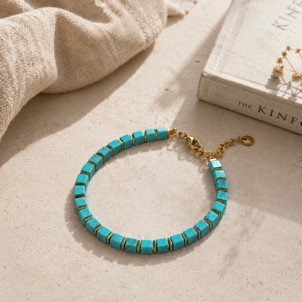 Turquoise and golden hematite bracelet styled on linen beside a book for calm and focus
