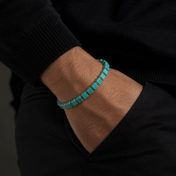 Turquoise bracelet with golden hematite worn on a man's wrist with a black sweater, Soultheory
