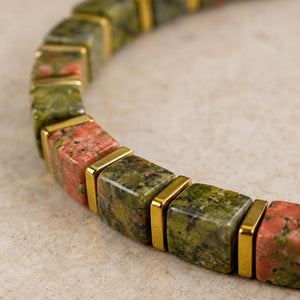 Close-up of unakite beads showing olive green and salmon pink mottling with gold spacers