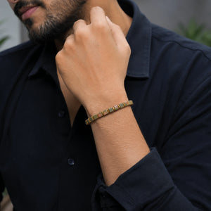 Unakite bracelet with golden hematite worn on a man's wrist with a navy shirt for grounding
