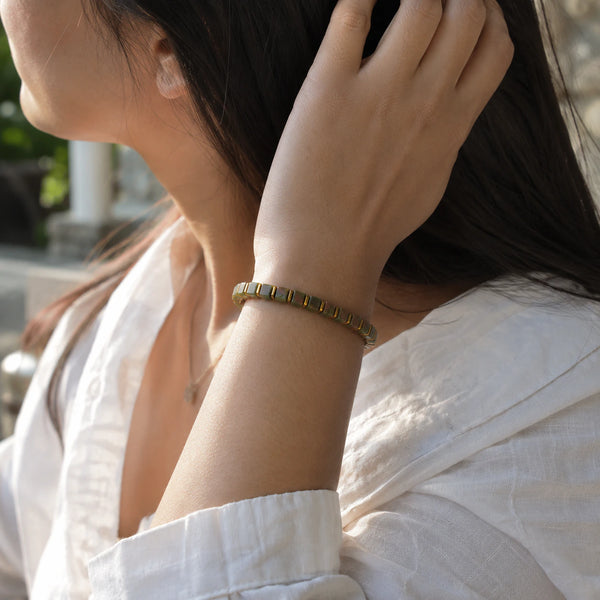 Unakite bracelet with golden hematite worn on a woman's wrist in a white shirt, Soultheory