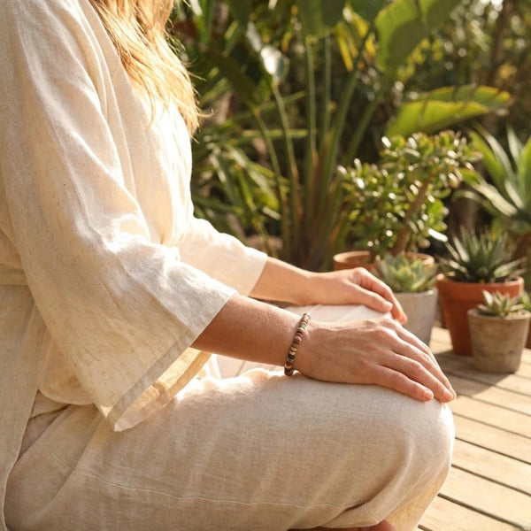 Woman meditating in a garden wearing a picasso jasper bracelet for calm creative energy