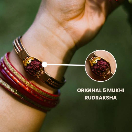 Copper rudraksha bracelet worn with red bangles, close-up showing original 5 mukhi bead