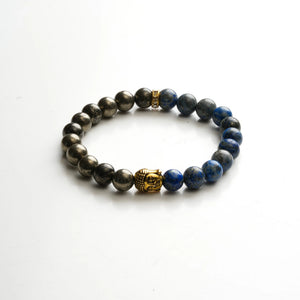 Flat lay of pyrite and lapis lazuli beads with gold Buddha charm on white background