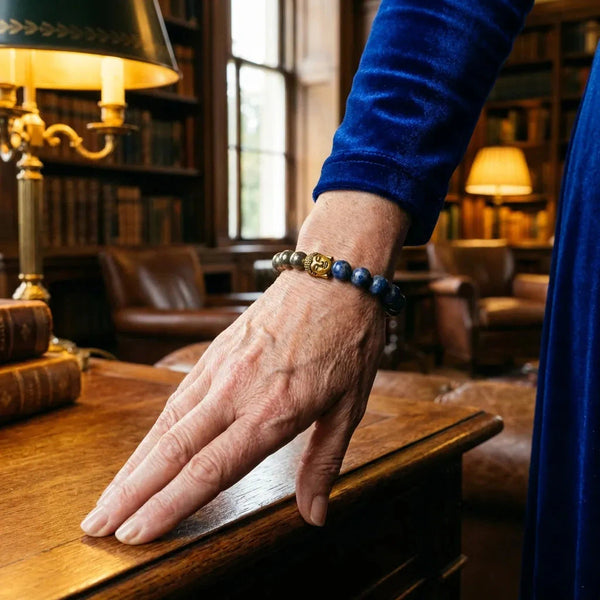 Man wearing pyrite and lapis lazuli bracelet at a library desk for wisdom and focus