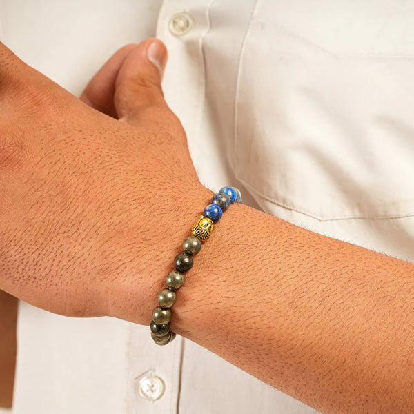 Pyrite and lapis lazuli bracelet worn on wrist with gold Buddha and blue and grey beads