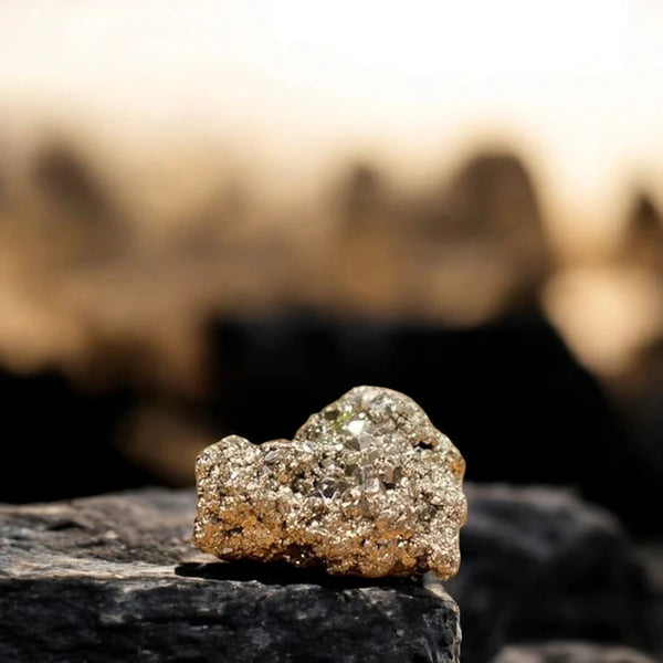 Raw pyrite Peru cluster stone on dark rock symbolising wealth and abundance