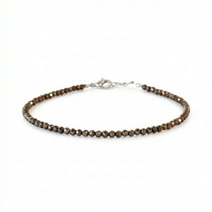 Raw pyrite faceted bead anklet with silver clasp on white background