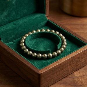 Raw pyrite bracelet displayed in a wooden gift box with green velvet lining