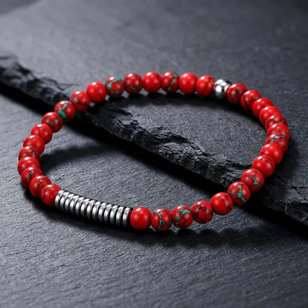 Red turquoise beads with green matrix veins and a hematite disc bar on dark slate