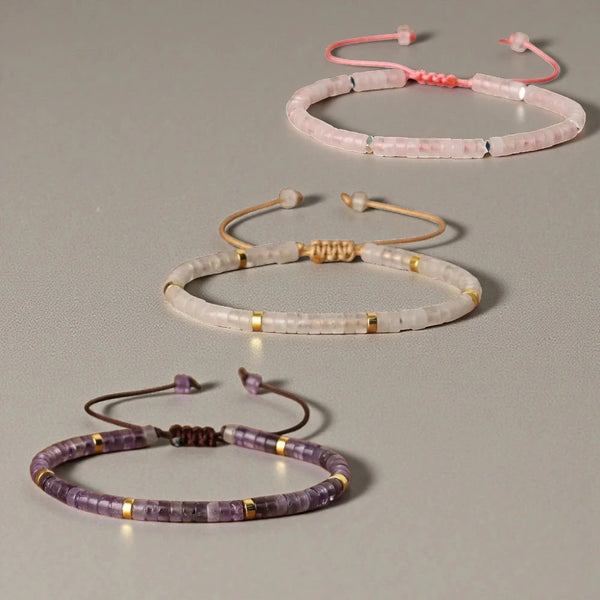 Rose quartz, clear quartz and amethyst adjustable bracelets laid out flat with gold accent beads