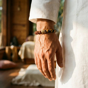 Rudraksha, pyrite and tiger eye bracelet styled on a man's wrist in soft daylight for calm focus