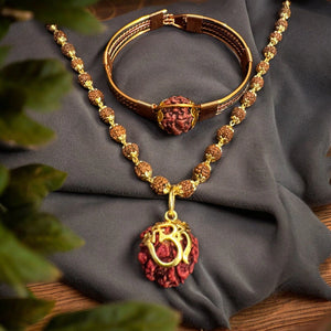 Gold plated Om Shree rudraksha necklace with pure copper rudraksha bracelet flat lay on grey cloth