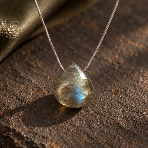 Macro of opaque side-threaded Labradorite pendant on fine cord