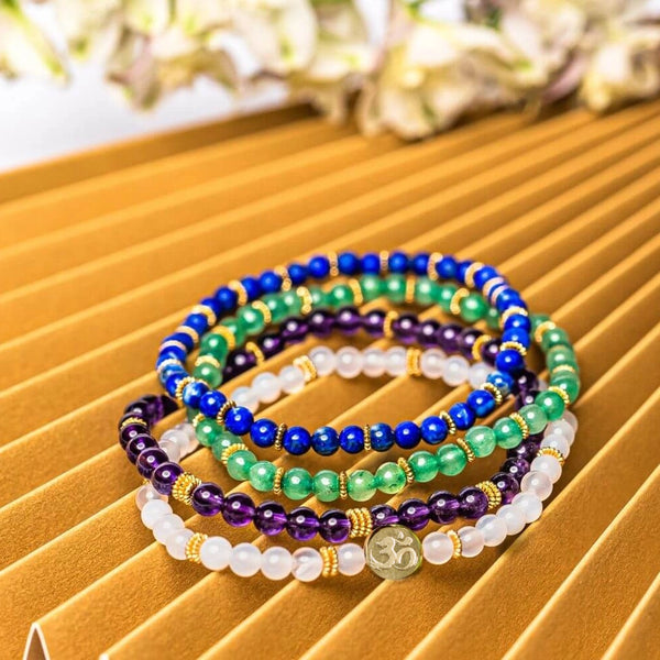 Four Soultheory Luck gemstone bracelets displayed together on a gold surface